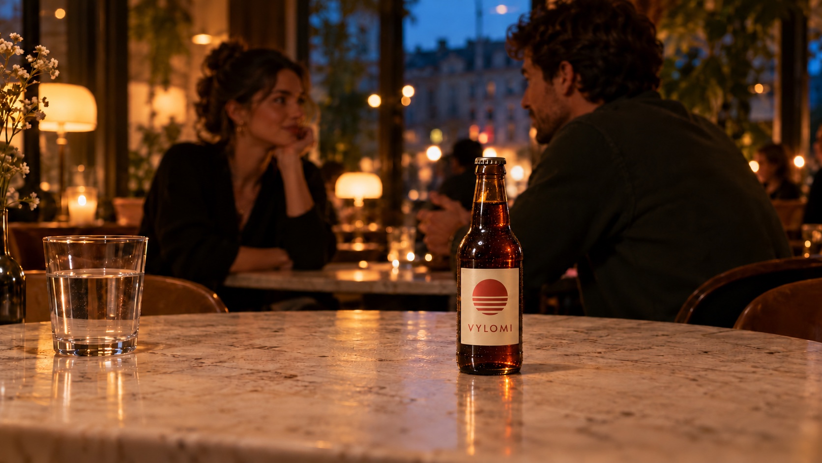 The café scene with a drink bottle on the foreground marble table.